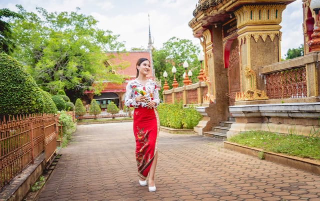 หญิงเอเชียในชุดประจำชาติที่วัดพุทธขนาดใหญ่