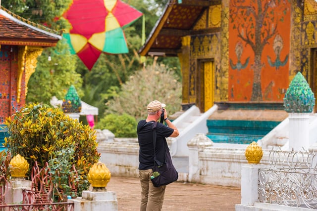 ชายคนหนึ่งกำลังถ่ายภาพวัดในหลวงพระบาง ประเทศลาว ชายคนหนึ่งกำลังถ่ายภาพวัดในหลวงพระบาง ประเทศลาว