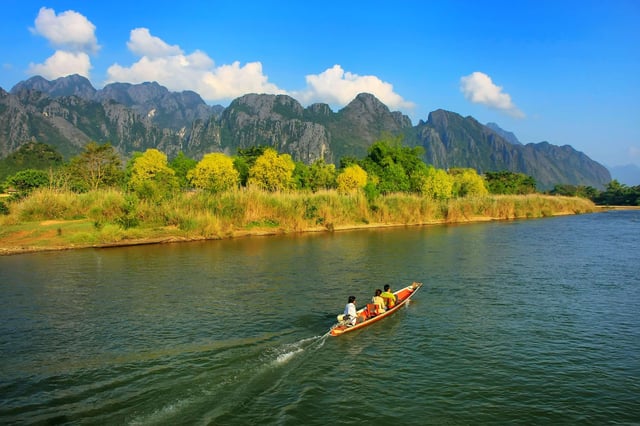 เรือยนต์แล่นบนแม่น้ำน้ำซองในเมืองวังเวียง ประเทศลาว วังเวียงเป็นจุดหมายปลายทางยอดนิยมของนักท่องเที่ยว
